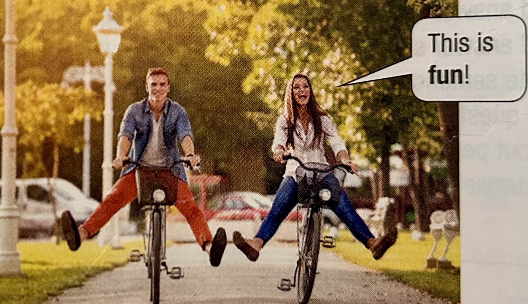 man and woman ride bicyles in city park having fun