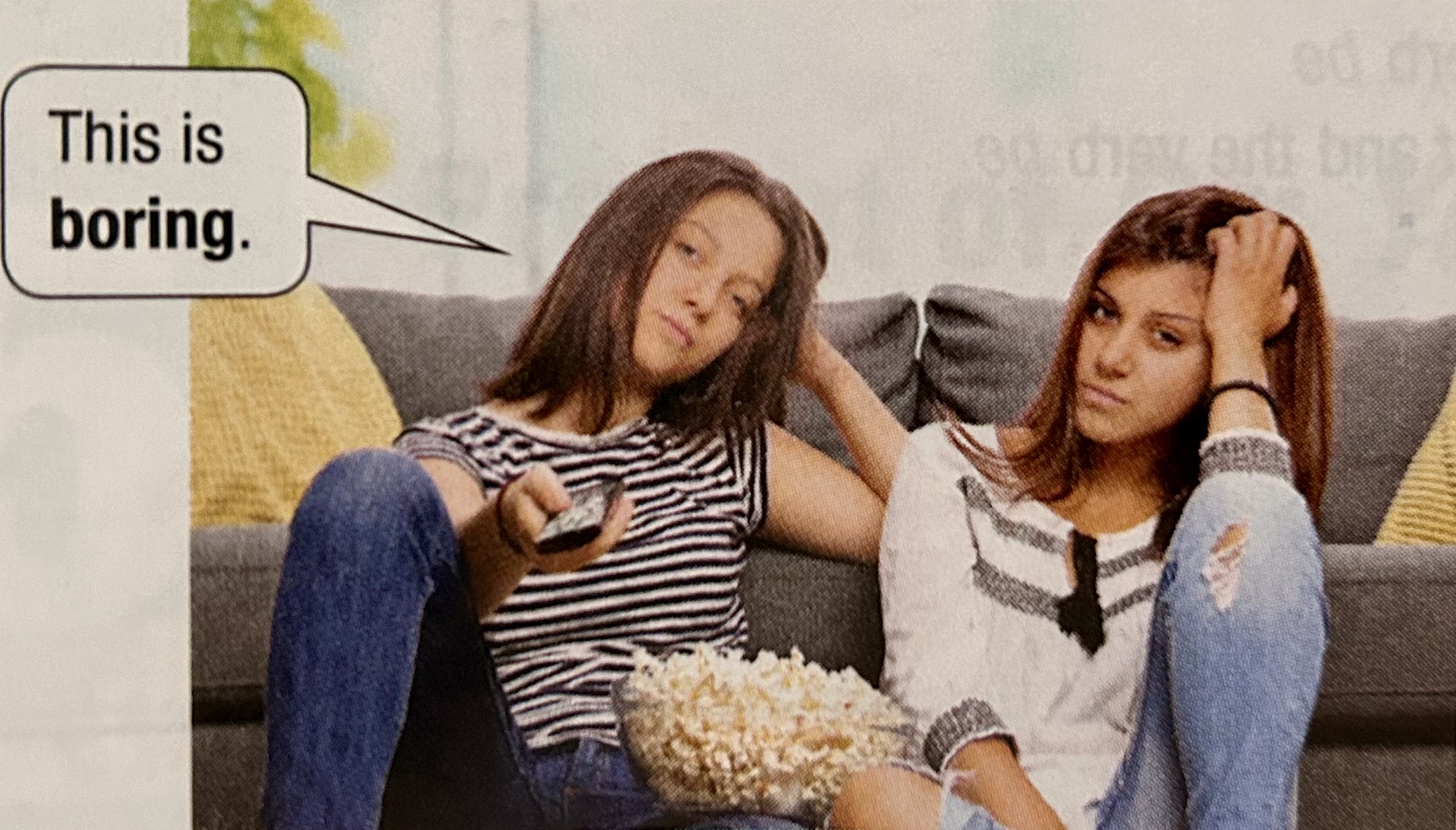 tow girls sitting down watch tv and say this is boring