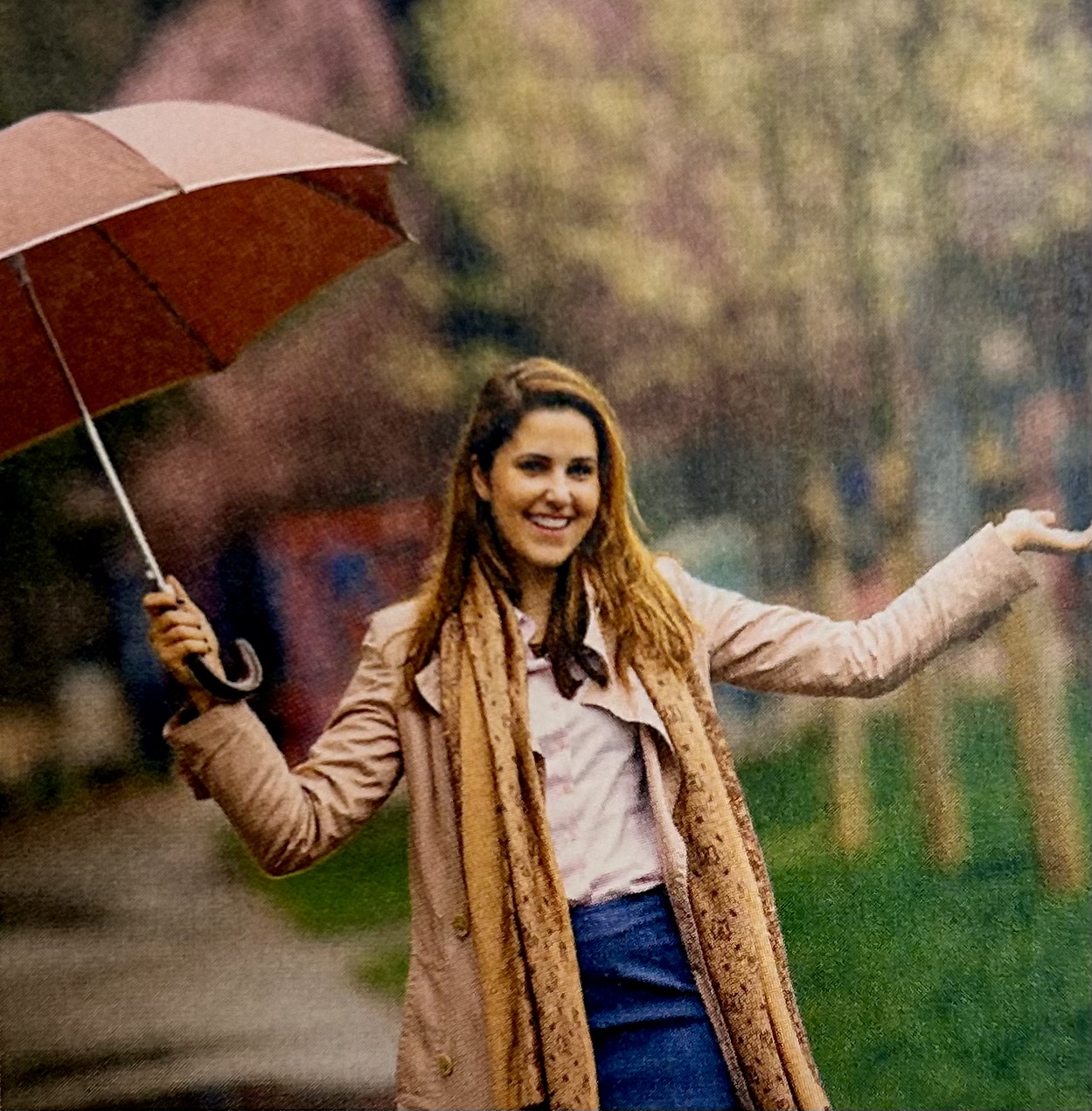 woman holds an umbrella in a city park and it rains